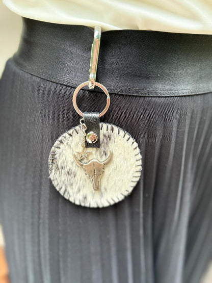 Leuke blikvanger, deze tas hanger die je trouwens ook als sleutelhanger kunt gebruiken.Gemaakt van koeienhuid(leer) en zilverkleurige Concho.
