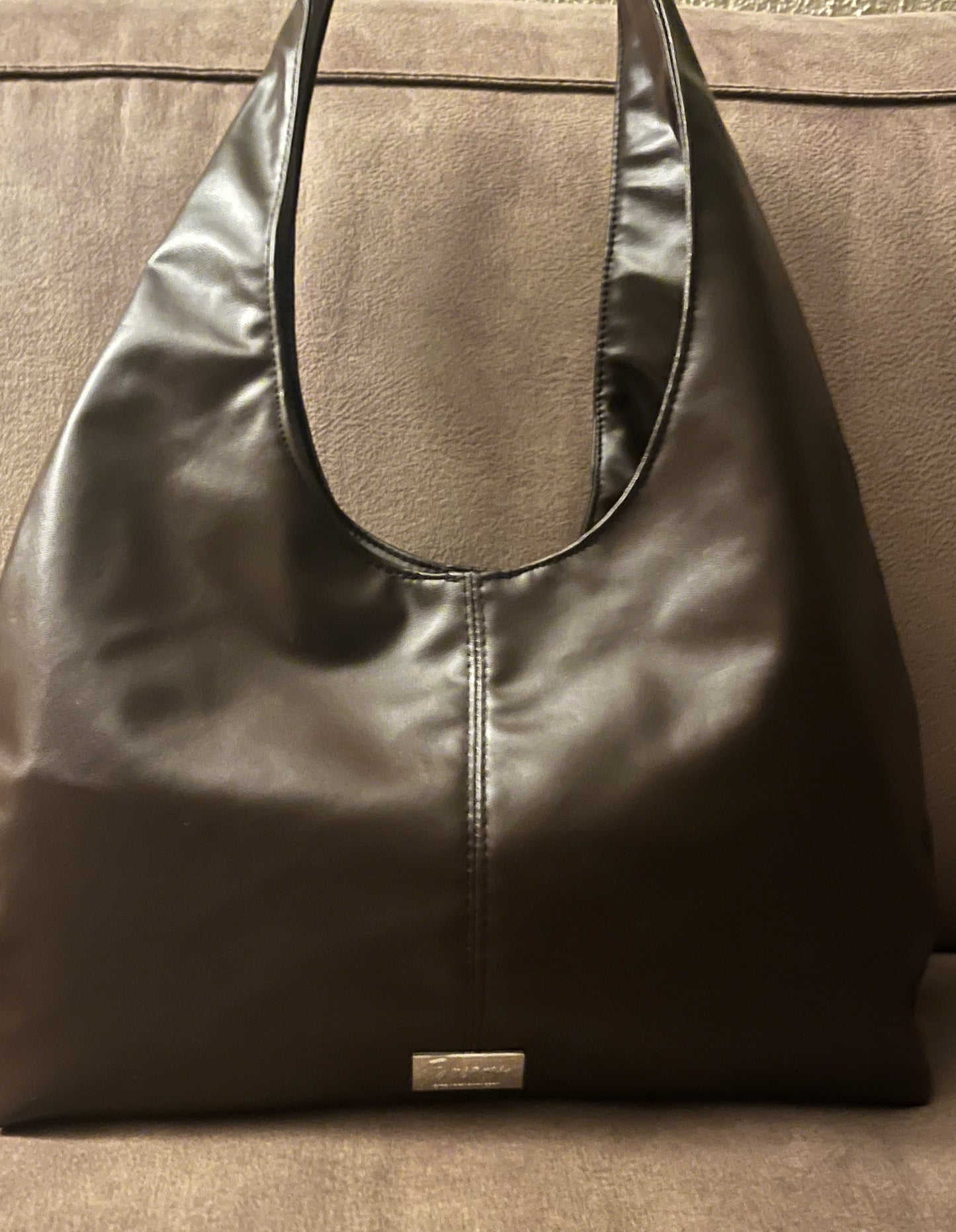 Deze handgemaakte hobo-tas is een perfecte balans tussen minimalistisch design en een subtiele wild touch.