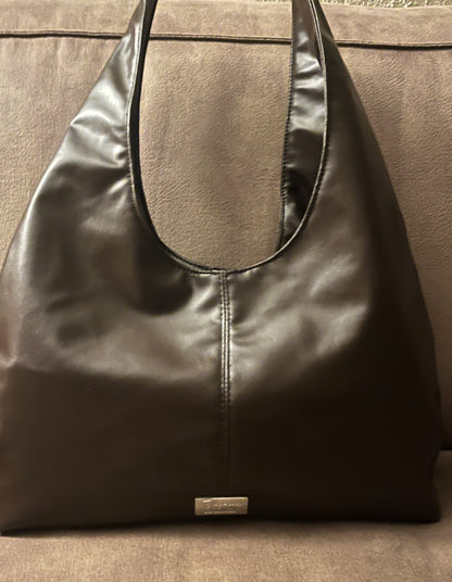 Deze handgemaakte hobo-tas is een perfecte balans tussen minimalistisch design en een subtiele wild touch.