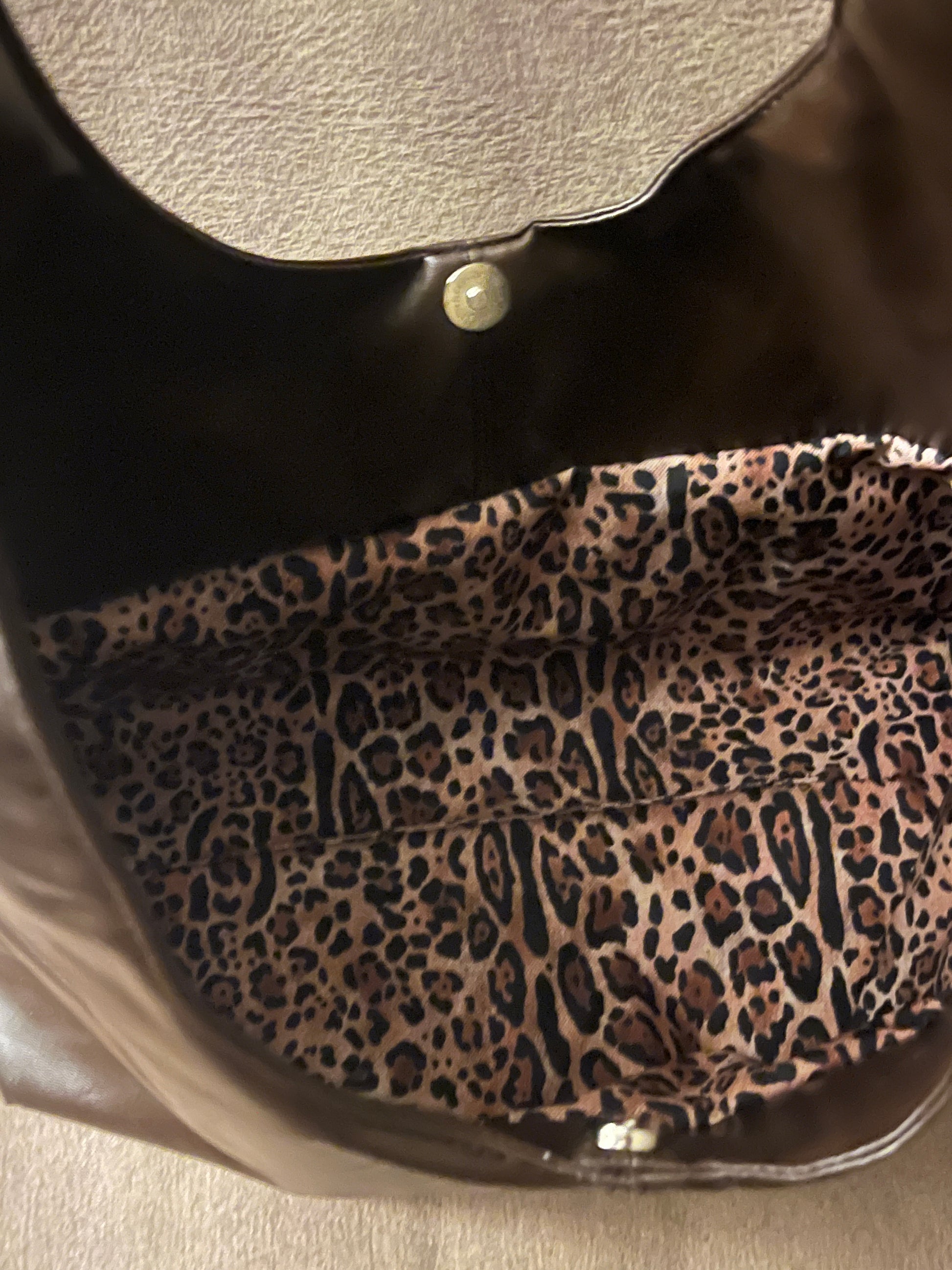 Deze handgemaakte hobo-tas is een perfecte balans tussen minimalistisch design en een subtiele wild touch.