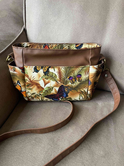 Prachtig gekleurde mini crossbody tas gemaakt van bruin skai en stof met een kleurrijke digitale vlinder print