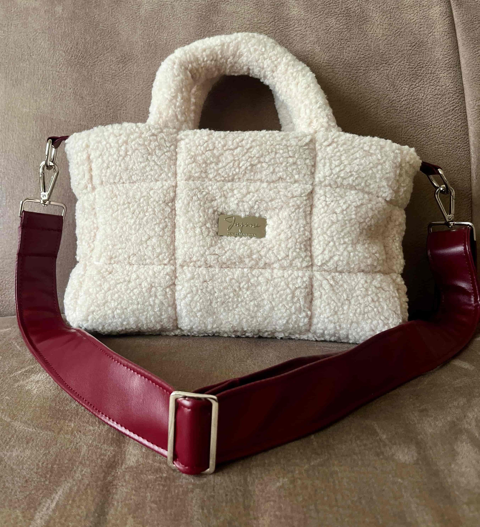 Zacht, stijlvol en met een luxe twist. Ivory & Wine is een handgemaakte teddy tas in een warme ivoortint, afgewerkt met een elegante bordeauxrode schouderband. 