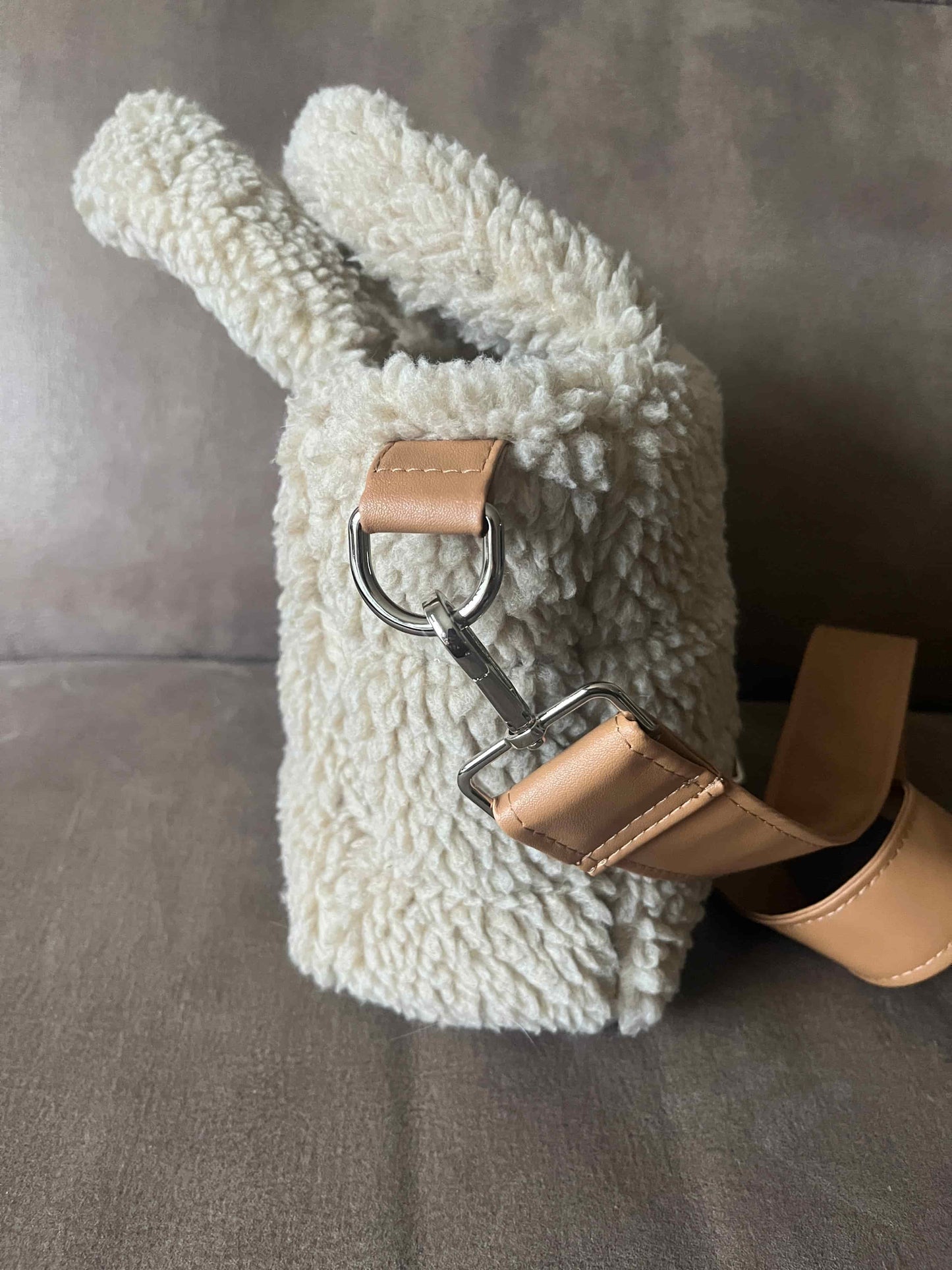 Omarm warmte en stijl met de Teddy Chic, de handgemaakte tas die comfort en elegantie perfect combineert. Gemaakt van superzachte Teddy-stof in een creamy beige tint, geeft deze tas elke outfit een knusse, luxueuze uitstraling