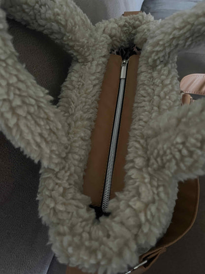 Omarm warmte en stijl met de Teddy Chic, de handgemaakte tas die comfort en elegantie perfect combineert. Gemaakt van superzachte Teddy-stof in een creamy beige tint, geeft deze tas elke outfit een knusse, luxueuze uitstraling