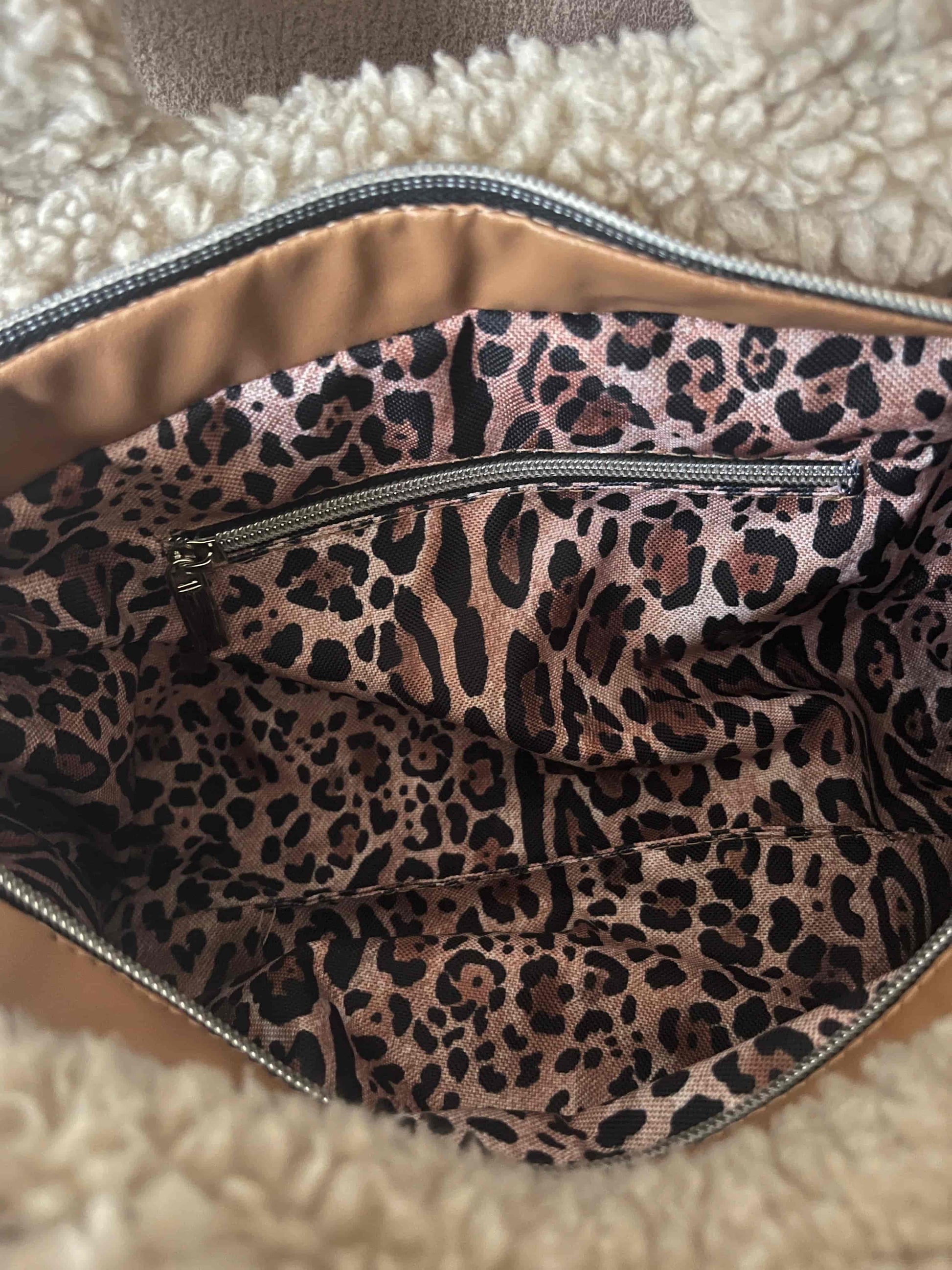 Omarm warmte en stijl met de Teddy Chic, de handgemaakte tas die comfort en elegantie perfect combineert. Gemaakt van superzachte Teddy-stof in een creamy beige tint, geeft deze tas elke outfit een knusse, luxueuze uitstraling