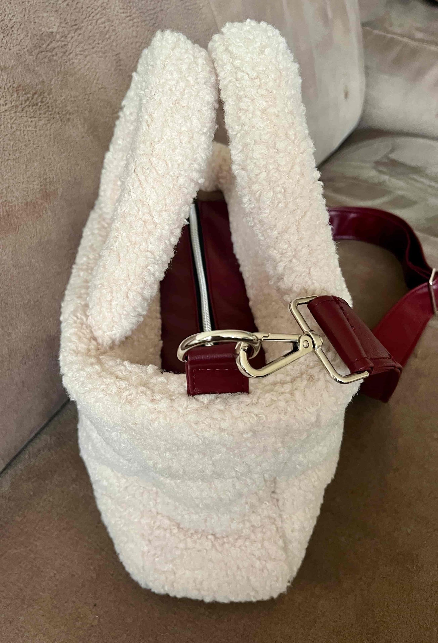 Zacht, stijlvol en met een luxe twist. Ivory & Wine is een handgemaakte teddy tas in een warme ivoortint, afgewerkt met een elegante bordeauxrode schouderband. 