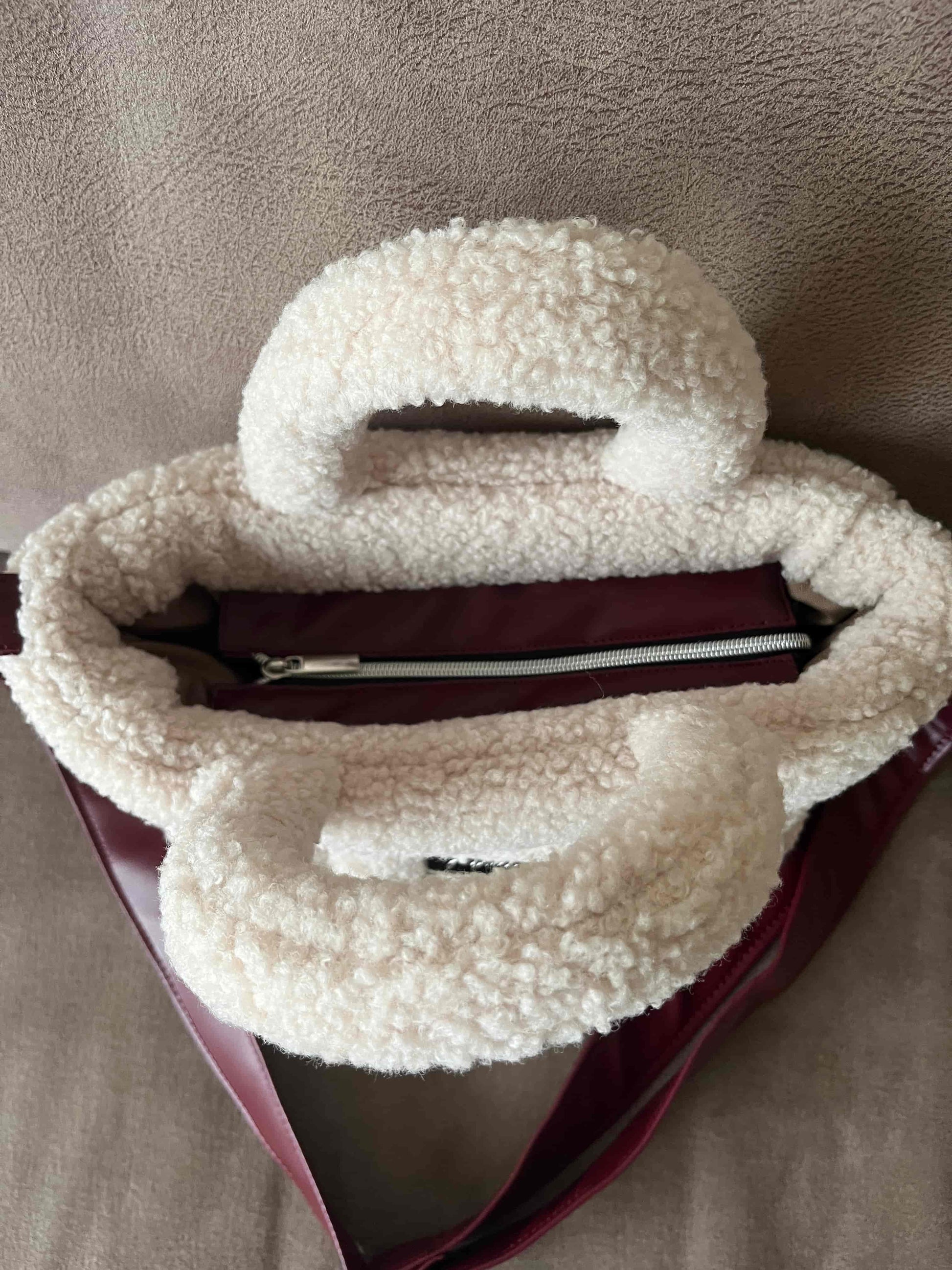 Zacht, stijlvol en met een luxe twist. Ivory & Wine is een handgemaakte teddy tas in een warme ivoortint, afgewerkt met een elegante bordeauxrode schouderband. 