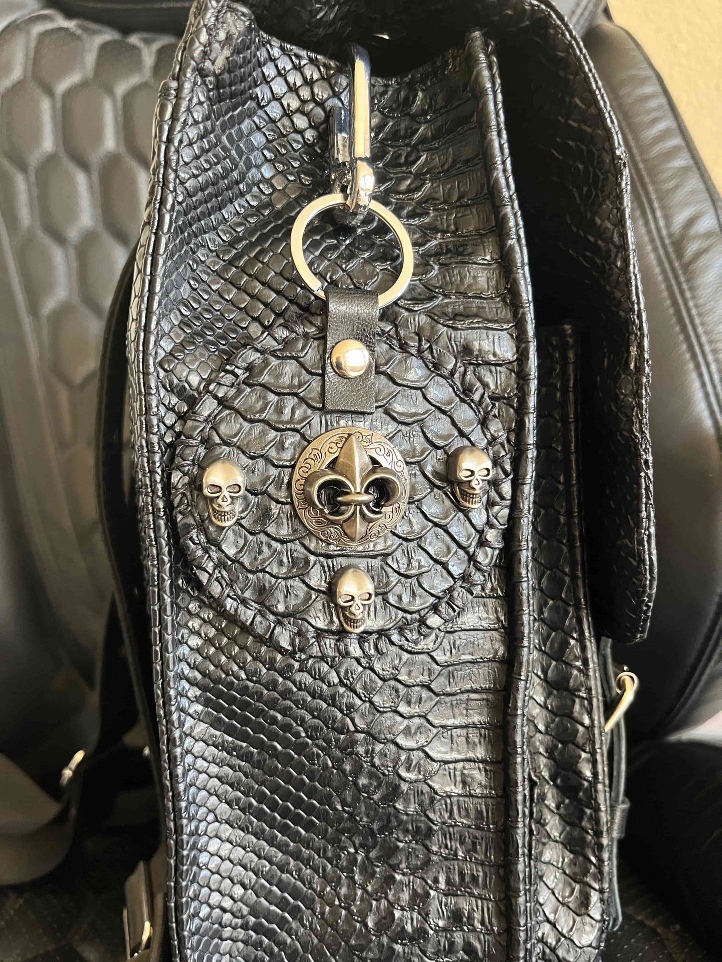 Handgemaakte stoere backpack tas in Gothic style met allerlei soorten studs en een kruis applicatie. De buitenkant van de tas is gemaakt van zwart kunstleer dat wat grove structuur heeft (krokodillenprint) en de binnenkant is van waterafstotende stof. De tas heeft een grote binnenvak en nog een klein binnenvakje met rits.