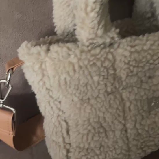 Omarm warmte en stijl met de Teddy Chic, de handgemaakte tas die comfort en elegantie perfect combineert. Gemaakt van superzachte Teddy-stof in een creamy beige tint, geeft deze tas elke outfit een knusse, luxueuze uitstraling
