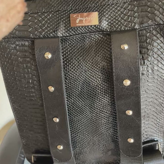 Handgemaakte stoere backpack tas in Gothic style met allerlei soorten studs en een kruis applicatie. De buitenkant van de tas is gemaakt van zwart kunstleer dat wat grove structuur heeft (krokodillenprint) en de binnenkant is van waterafstotende stof. De tas heeft een grote binnenvak en nog een klein binnenvakje met rits.