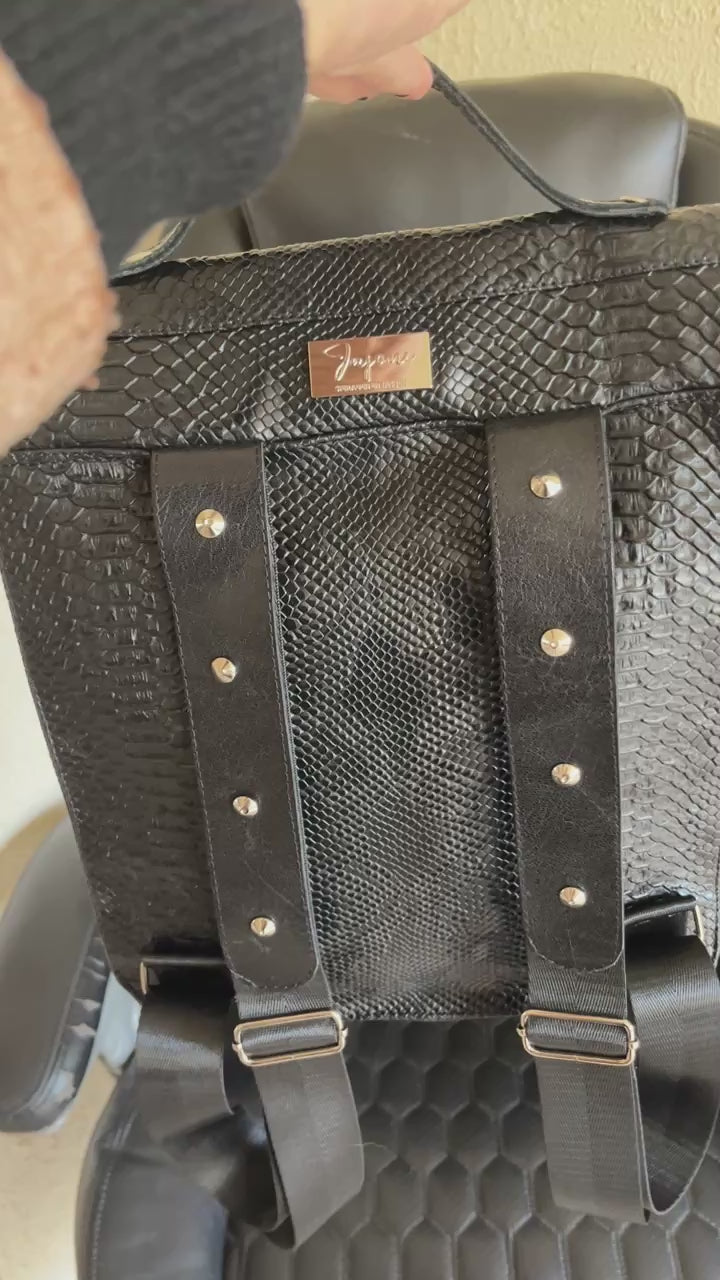 Handgemaakte stoere backpack tas in Gothic style met allerlei soorten studs en een kruis applicatie. De buitenkant van de tas is gemaakt van zwart kunstleer dat wat grove structuur heeft (krokodillenprint) en de binnenkant is van waterafstotende stof. De tas heeft een grote binnenvak en nog een klein binnenvakje met rits.