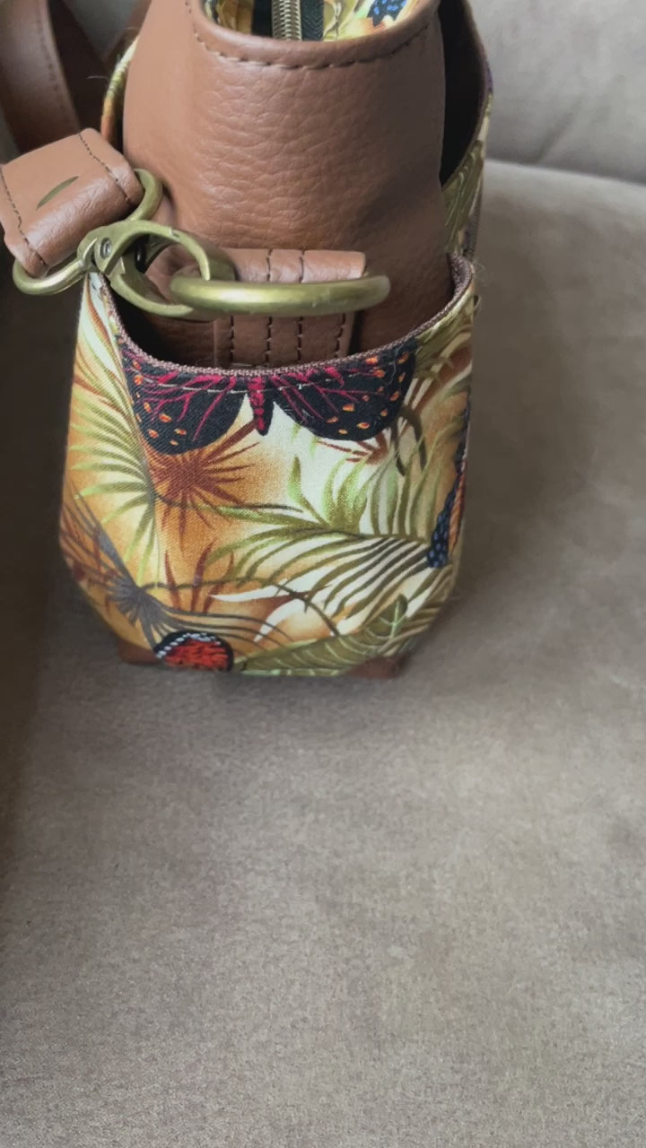 Prachtig gekleurde mini crossbody tas gemaakt van bruin skai en stof met een kleurrijke digitale vlinder print