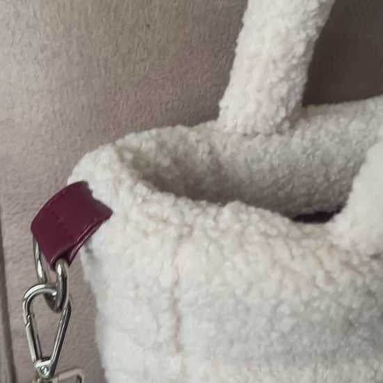 Zacht, stijlvol en met een luxe twist. Ivory & Wine is een handgemaakte teddy tas in een warme ivoortint, afgewerkt met een elegante bordeauxrode schouderband. 