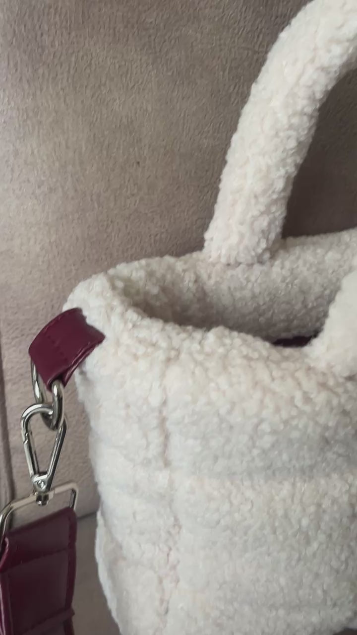 Zacht, stijlvol en met een luxe twist. Ivory & Wine is een handgemaakte teddy tas in een warme ivoortint, afgewerkt met een elegante bordeauxrode schouderband. 
